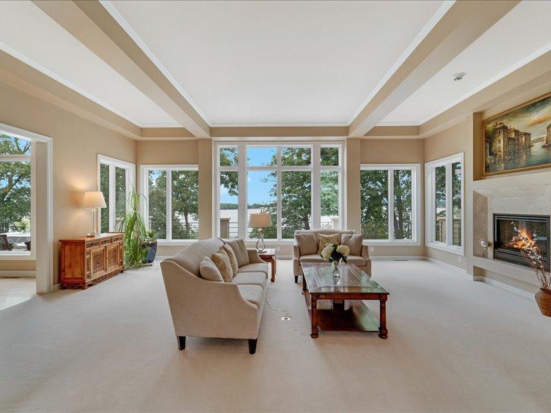 Main floor living room, tall ceilings, huge windows that provide an abundance daylight and lake views.