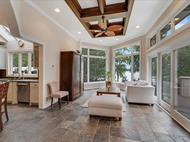 Sun room with heated tile floor, large windows, and amazing lake views, a perfect place to watch the sunset.