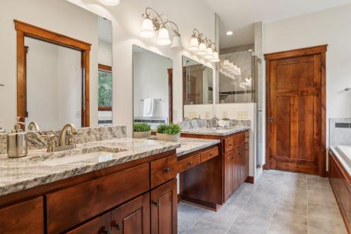 The private primary bathroom features heated tile floors, double vanities with granite, a soaking tub, separate walk-in tiled shower, private water closet and dual walk in closets!