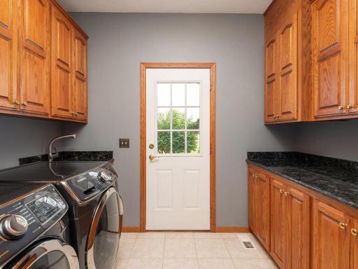 Main level Laundry Room has more cabinetry for storage and a utility sink.