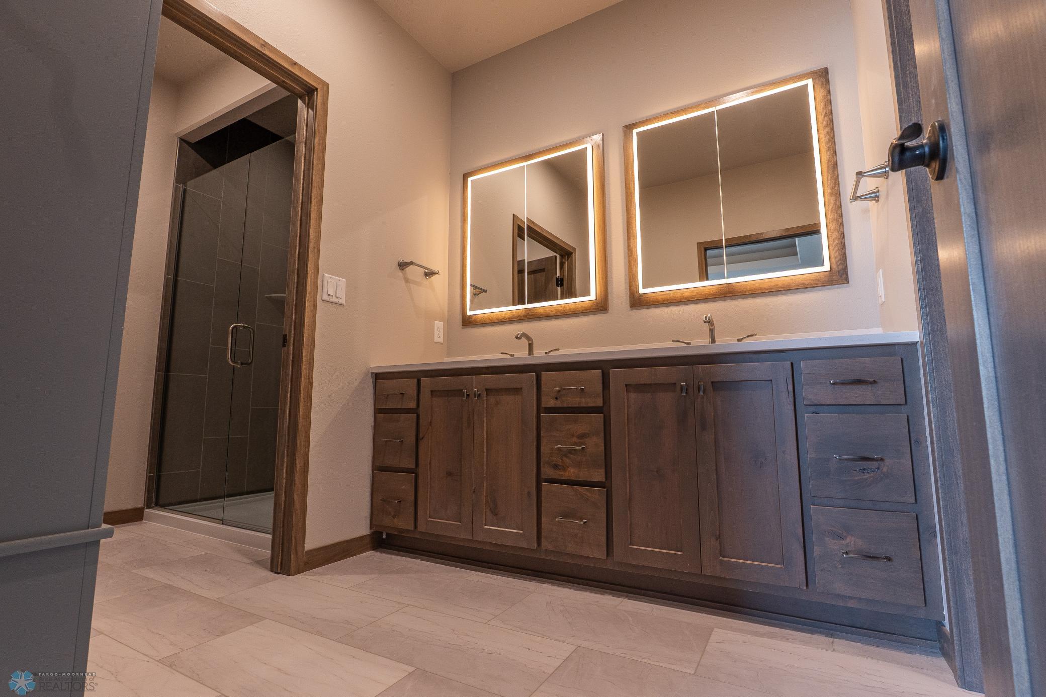 Primary Bathroom with tile shower, floors and quart counter tops.