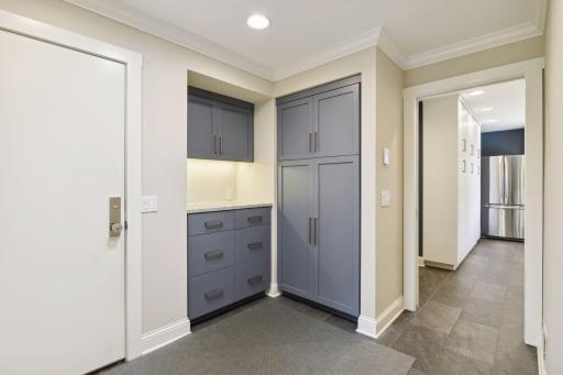 Mud room area features a custom "drop zone" with a message center and granite counter top adjacent to the laundry room and butler's pantry