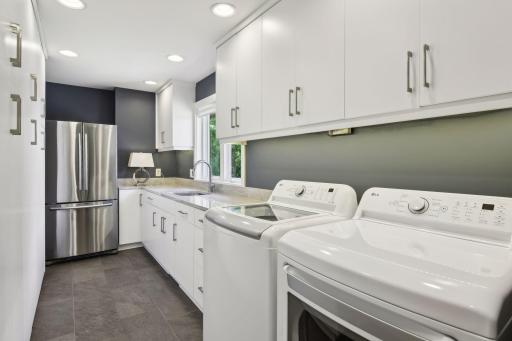 Lovely main level laundry room doubles as a butler's pantry with abundant custom storage, granite countertops and new appliances