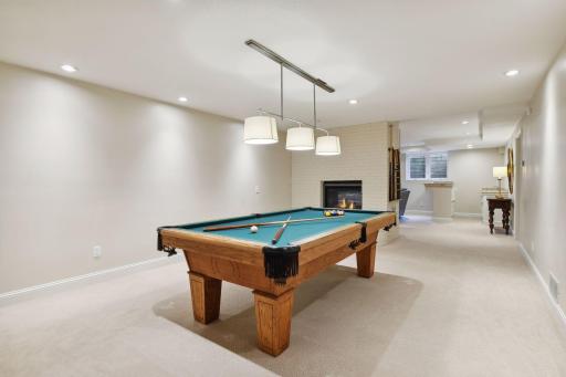 Large lower level entertainment area includes an amusement room which flows seamlessly into a family room with a wet bar