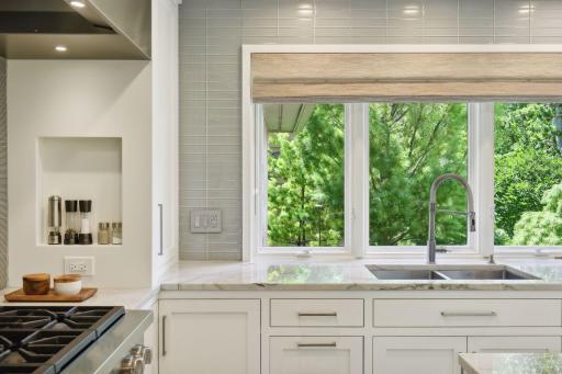 Experience the luxury of Quartzite countertops paired with soft-close cabinets, all bathed in natural light that enhances the beauty and functionality of this meticulously designed kitchen