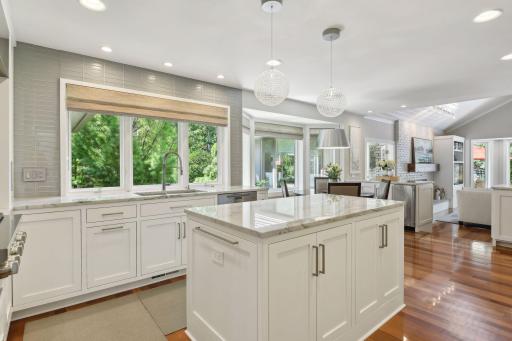 A chefâs dream kitchen, completely remodeled with luxurious finishes, custom cabinetry, and bay windows. The center island and open concept design seamlessly connect the space to the dining area and cozy hearth room