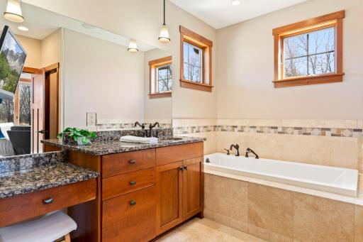 Primary Bath with heated floors, over sized tub, private stool, his/her counters/sinks and make-up area with drawer for heated items