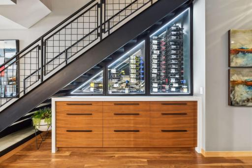 Custom temperature controlled Wine Cellar featuring Cambria Quartz and custom cabinetry for bar storage and other essentials
