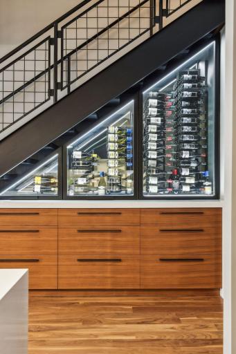 Custom temperature controlled Wine Cellar featuring Cambria Quartz and custom cabinetry for bar storage and other essentials