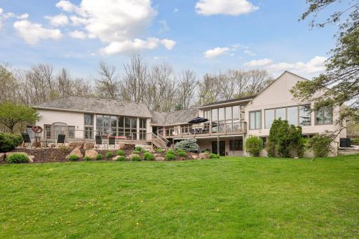 Bright oversized windows wrap around this gorgeous backyard showing off the wooded privacy.