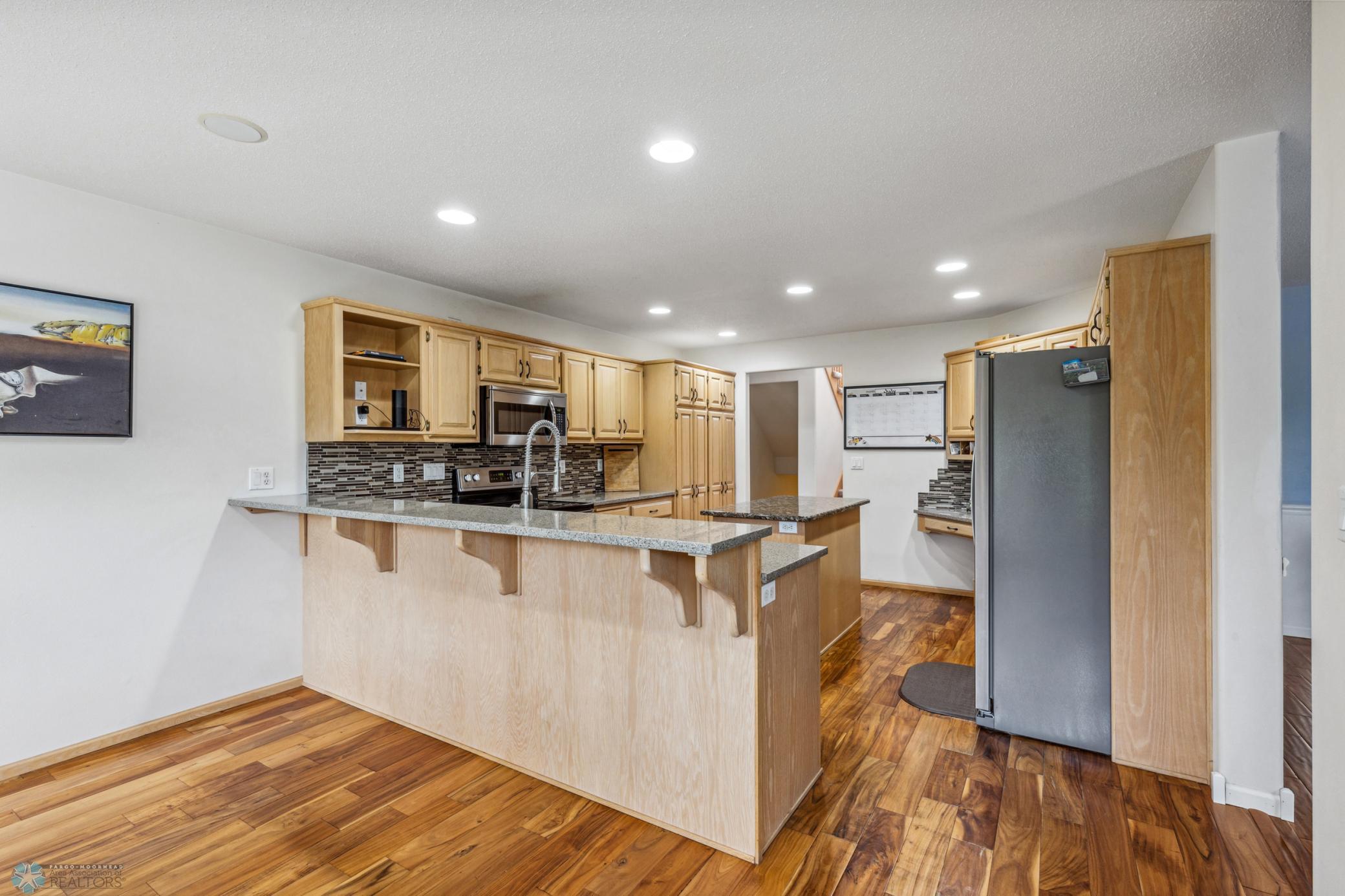 Kitchen with Stainless Appliances Granite Countertops and Tile Backsplash