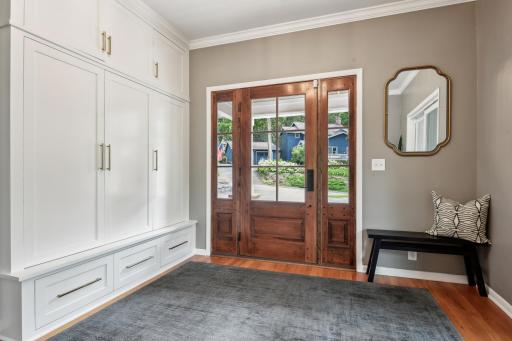 This fabulous entryway greets you and that door is incredible! A custom designed floor to ceiling storage wall system is ideally positioned in the entry.