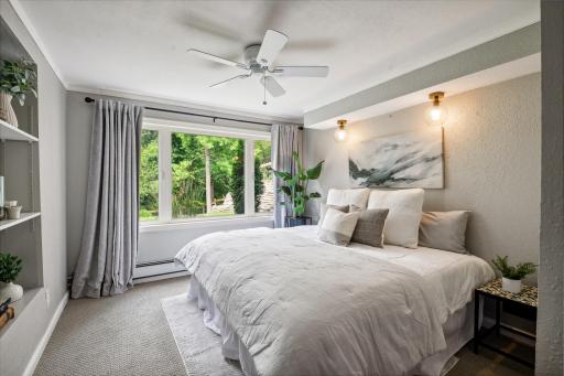 Bright and airy lower level bedroom has scenic views.