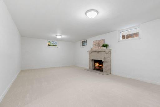 Lower Level Family Room offers a wood burning fireplace w/ brick surround
