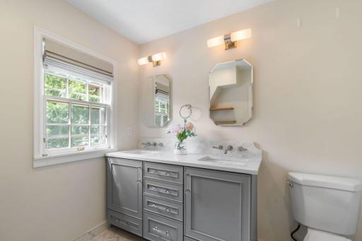 Enameled vanity cabinet with marble top and backsplash, dual sinks and wall mounted faucet