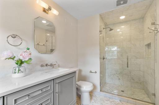 Master Bathroom features a custom shower, enameled vanity cabinet w/ marble top and mosaic marble tile flooring