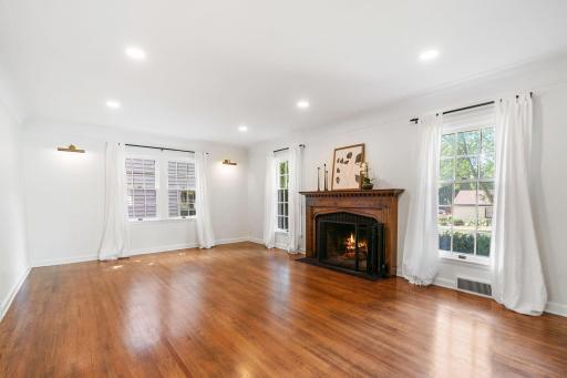 The Living Room offers a wood burning fireplace with original brick and antique surround, coved ceilings with molding and is spacious in size!
