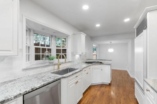 Enameled cabinetry features glass doors, full height pantry door, roll-out storage, under cabinet lighting, open display shelving and raised âEat-Inâ breakfast bar