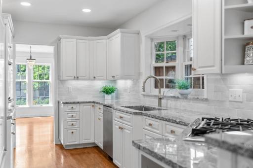 Appliances include a cabinet paneled SubZero refrigerator, KitchenAid dual wall ovens, Frigidaire gas cooktop and Bosch dishwasher