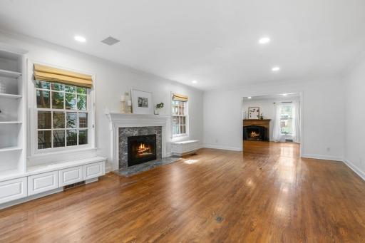 Main level Family Room features a 2nd wood burning fireplace with marble surround and enameled mantel, built-in benches and bookcase