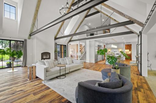 The great room boasts a cozy Accucraft wood-burning fireplace with a white brick surround, dual-access sliding doors to the front porch, and an abundance of sunlight streaming through extra windows.