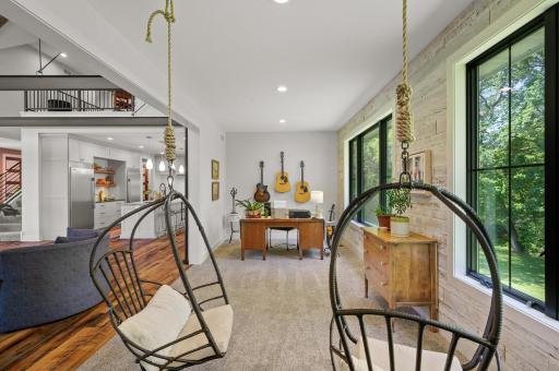 This space offers stunning backyard views, a gas-burning stove, and charming hanging chairs.