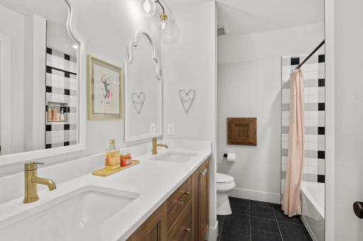 Two bedrooms are only steps away from the full shared bathroom with a tub/shower combo, dual vanity, and laundry chute.