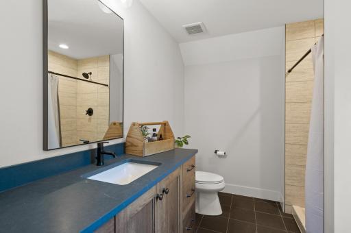 The fourth bedroom includes a private ensuite bathroom with a walk-in shower stall.