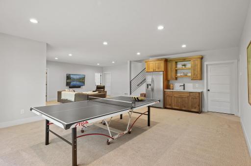 Recreation room includes a convenient wet bar with a full-size refrigerator.
