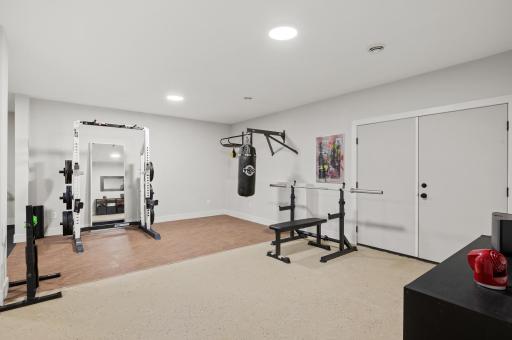 The lower-level bonus room, currently used as a workout room, offers access to the outdoors through double doors.