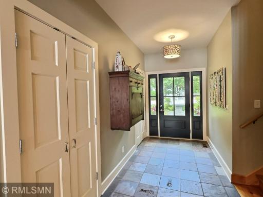 Enter into a spacious foyer with two coat closets, slate flooring with accent squares and upgraded lighting.