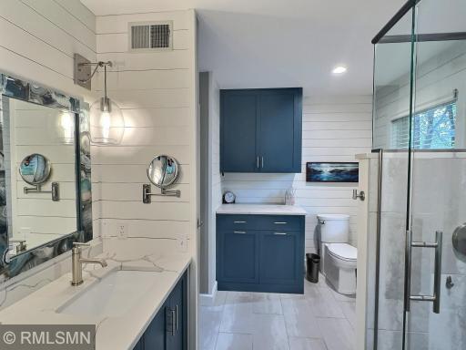 The primary private bathroom is finished with custom edged mirrors, shiplap walls and tons of cabinet space.