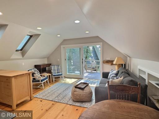 Drenched with natural light, the living space of the bunkhouse has a sliding glass door leading to a deck.