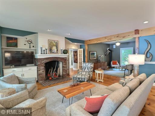 Warmed by a wood burning fireplace, the living rooms has custom built-ins with shiplap and wood accents.