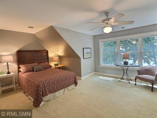 The first bedroom in the upper level is large with a ceiling fan, closet and breathtaking views of the lakeshore.