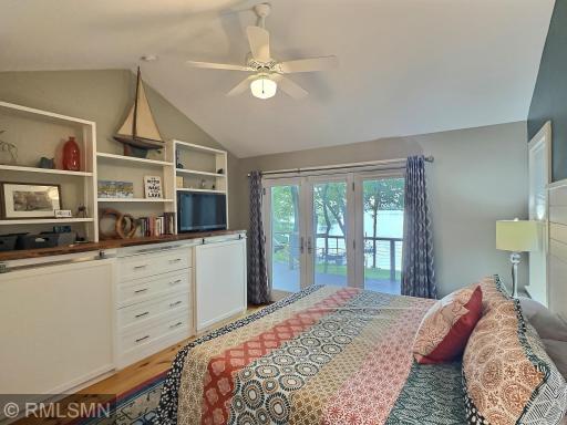 A custom built-in dresser with live edge counter and shelves is the centerpiece of the primary bedroom.