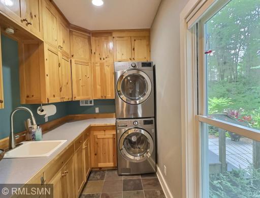Just down the hall from the mud room is a laundry room with slate flooring, sink and lots of cabinet space.