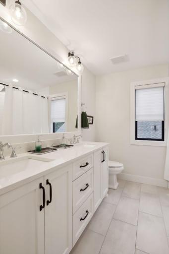 Second level full bathroom with heated floors, and a double sink vanity.