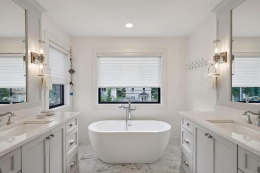 Two custom vanities, a soaker tub, and walk-in shower.
