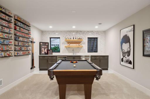 Built-in bar with quartz counters, white oak floating shelves, under cabinet lighting, a beverage fridge and dishwasher.