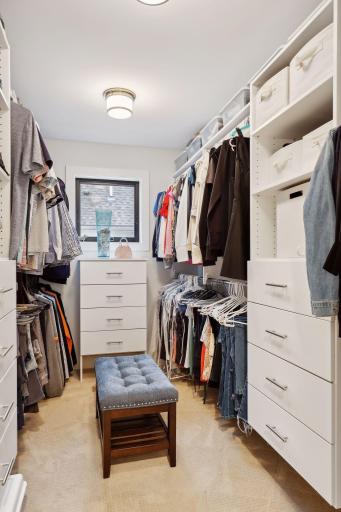 Large walk-in closet with custom organizers and dressers.