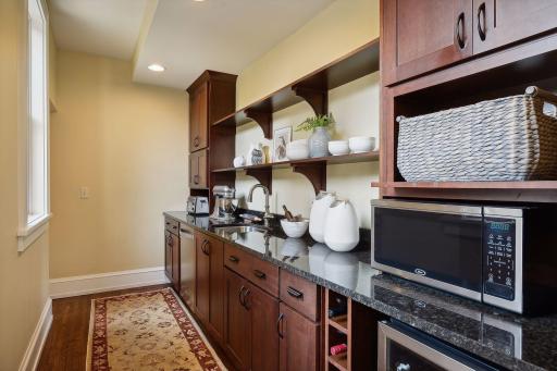 Large butler's pantry and coffee bar connect the formal dining room and kitchen.