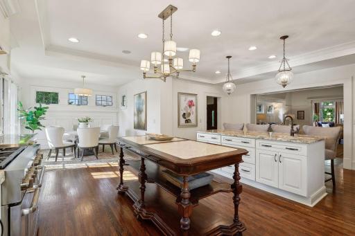 Spacious and sun-drenched kitchen with adjacent family room and library. A hallway leads to a main level powder room and mudroom with access to the front patio and garden.