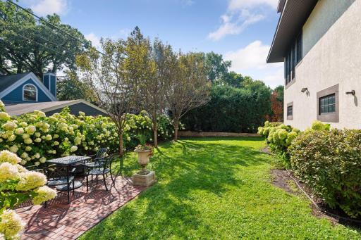 Beautiful private backyard with brick paver patio and lovely landscaping wraps around south side of home to front yard.