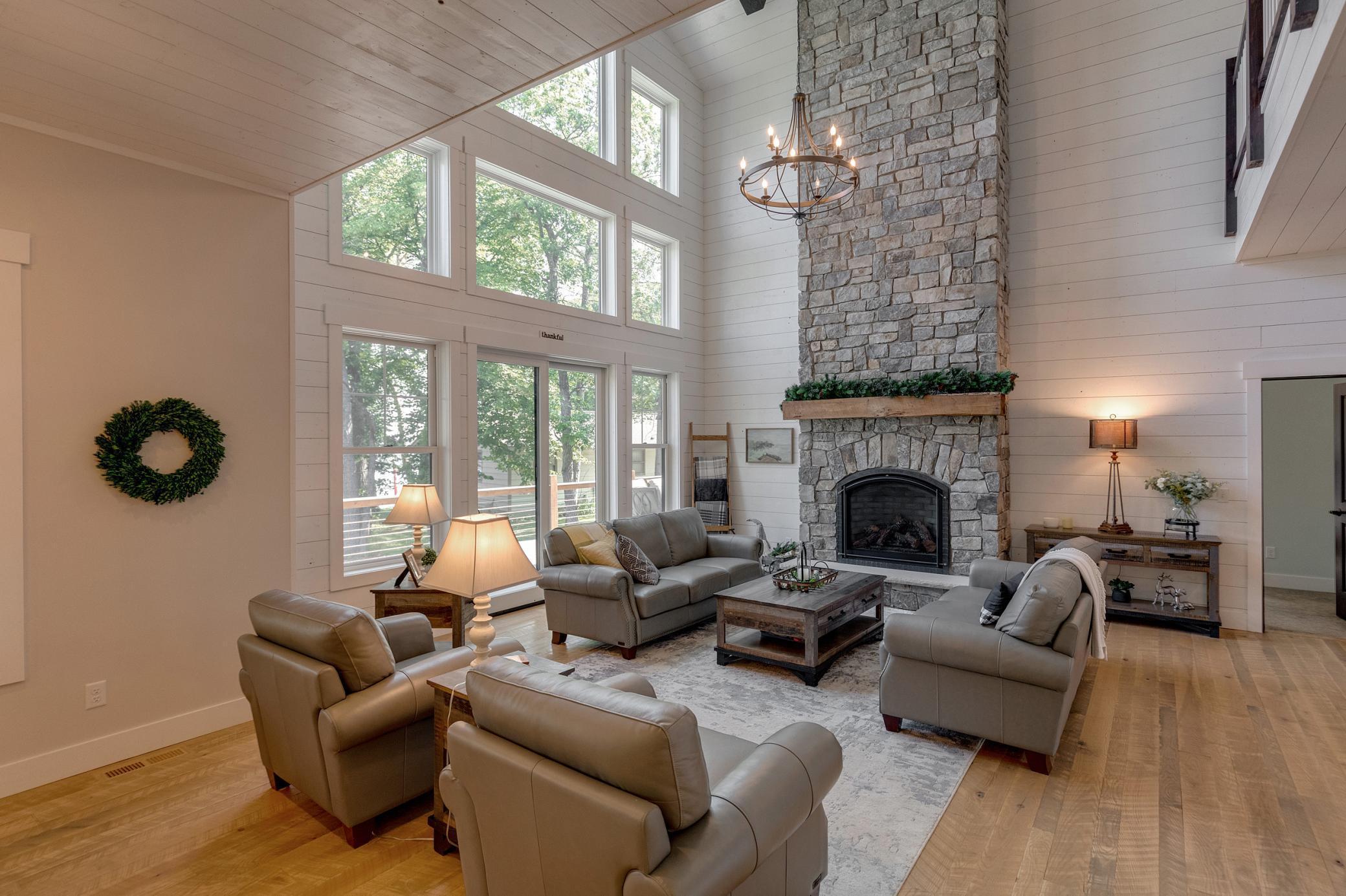 Main level great room featuring cathedral ceilings and a stone fireplace