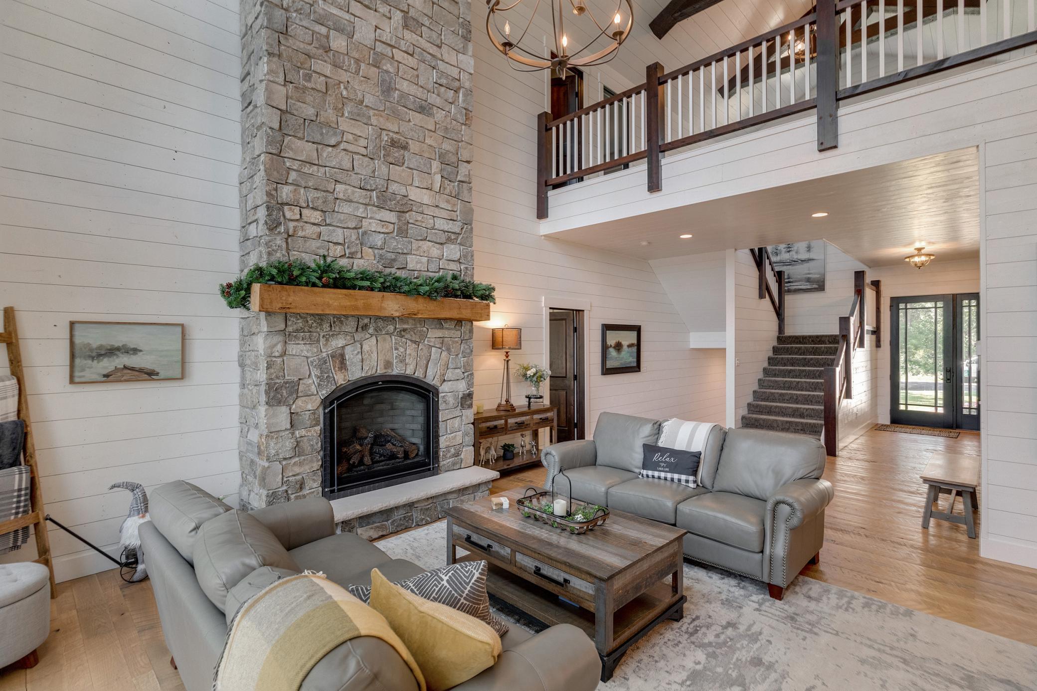 Main level great room featuring cathedral ceilings and a stone fireplace