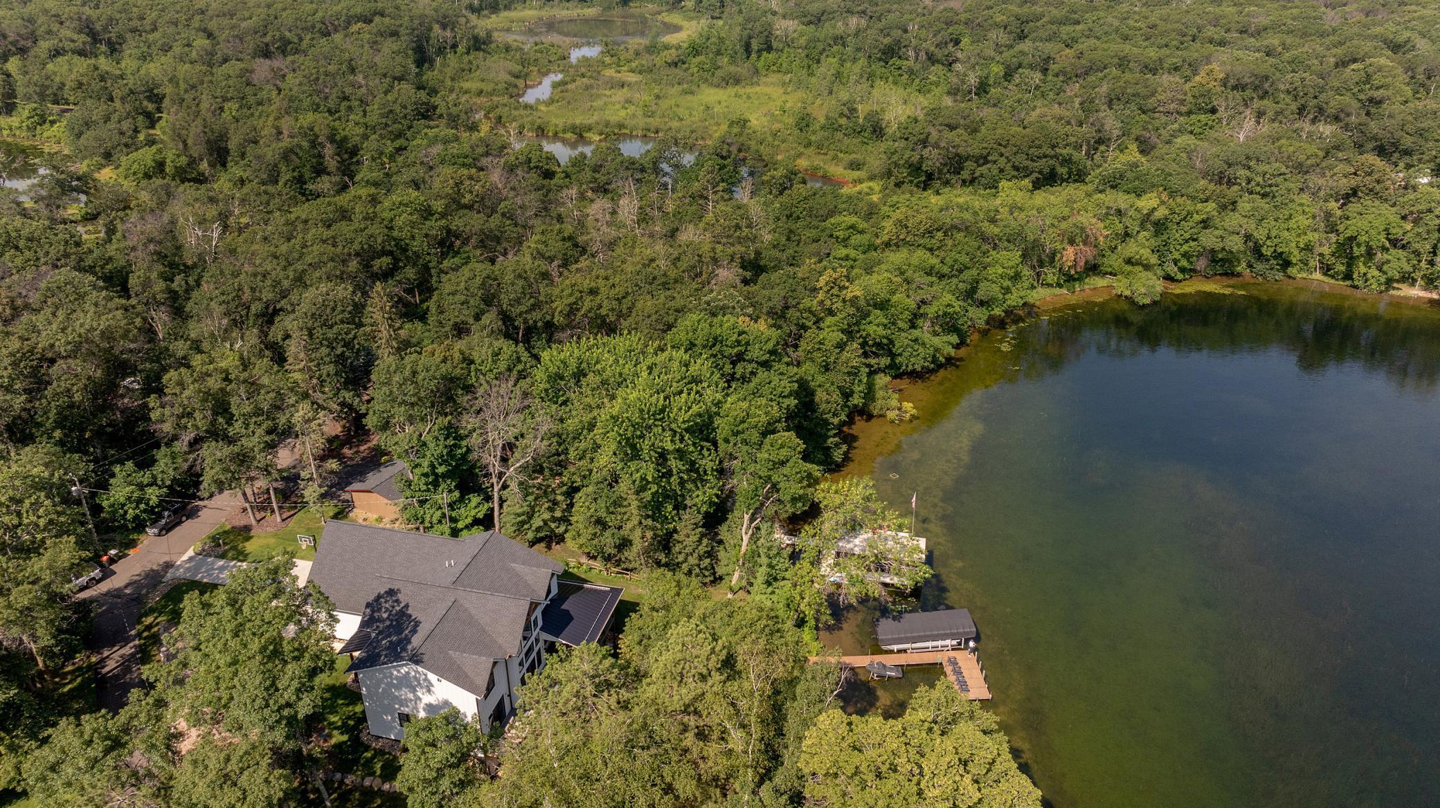 Mature trees surround this luxury lake front two story.