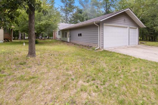 Three car garage with concrete drive and extra tall overhead doors.