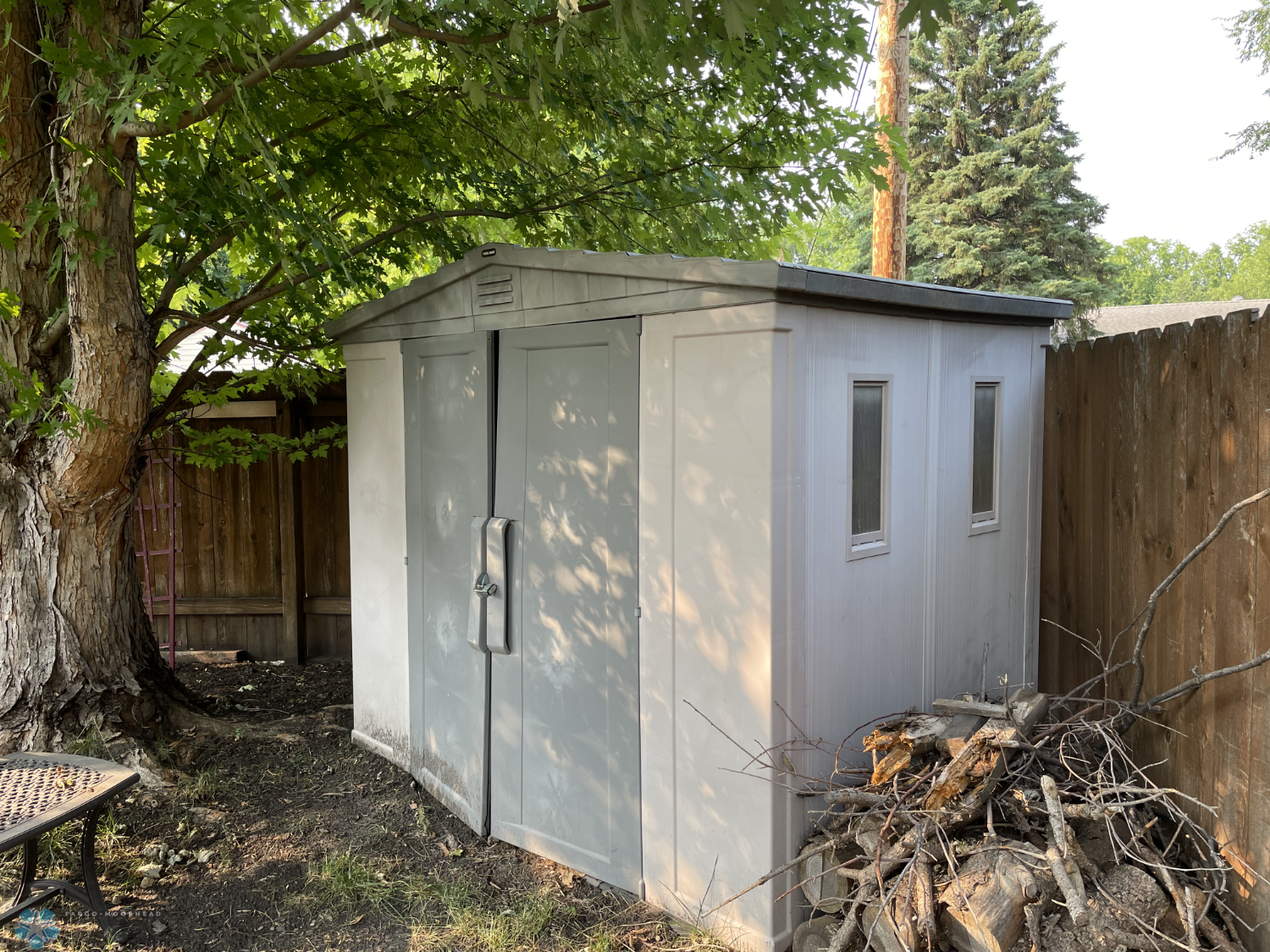 Plastic storage shed in the fenced yard.png