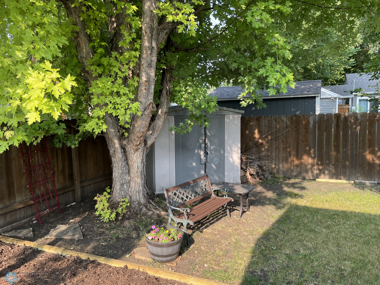 Plastic storage shed in fenced yard.png
